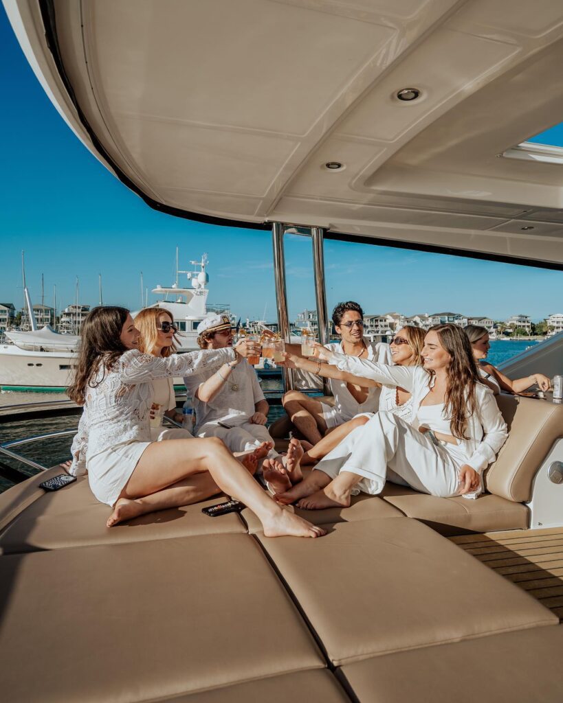 group of men and women cheers on a yacht
