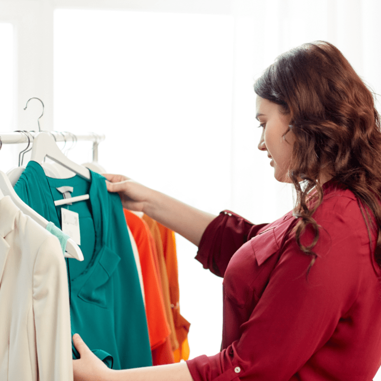 young woman looking at a shirt on clothing rack; size inclusivity body positivity Arth Real Estate Wilmington, North Carolina