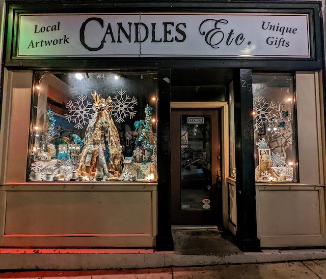 Candles Etc. holiday window display from 2021 featuring blue and silver decorations
