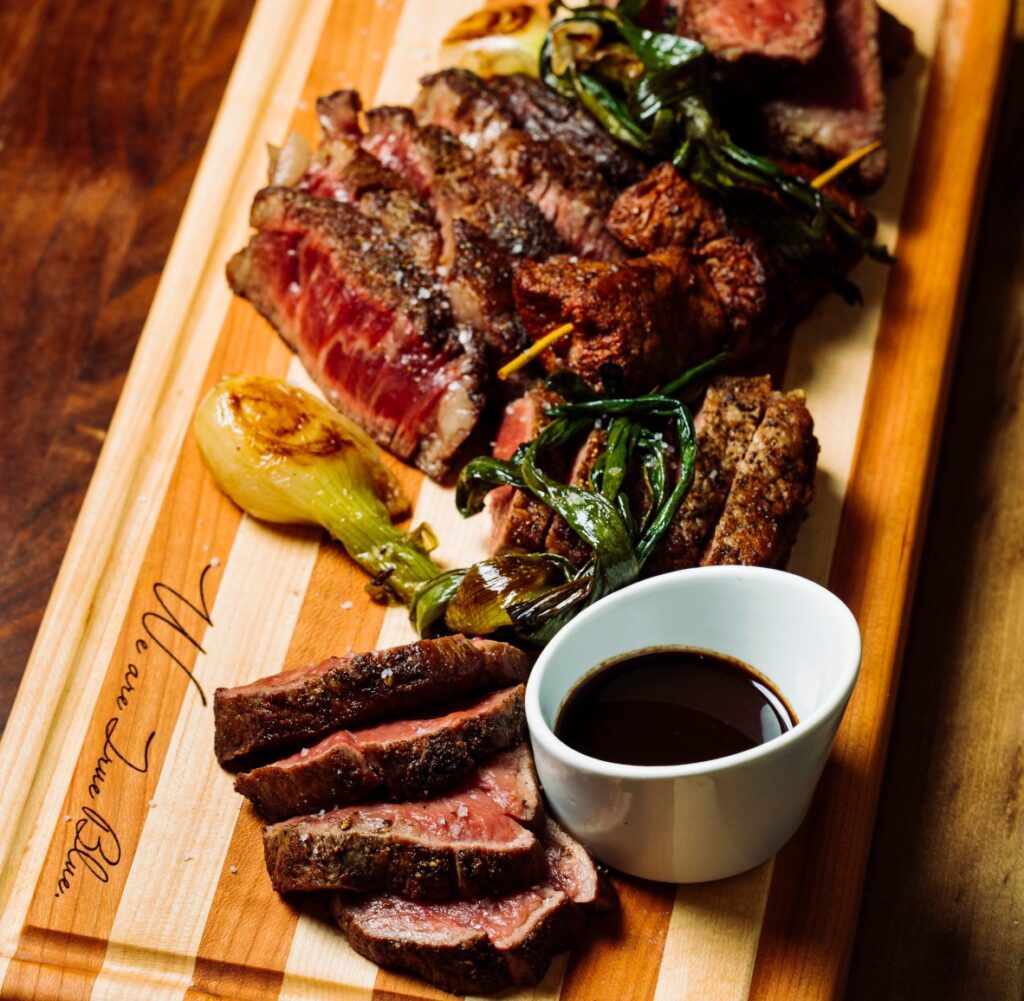 cutting board with sliced steak True Blue Butcher and Barrel