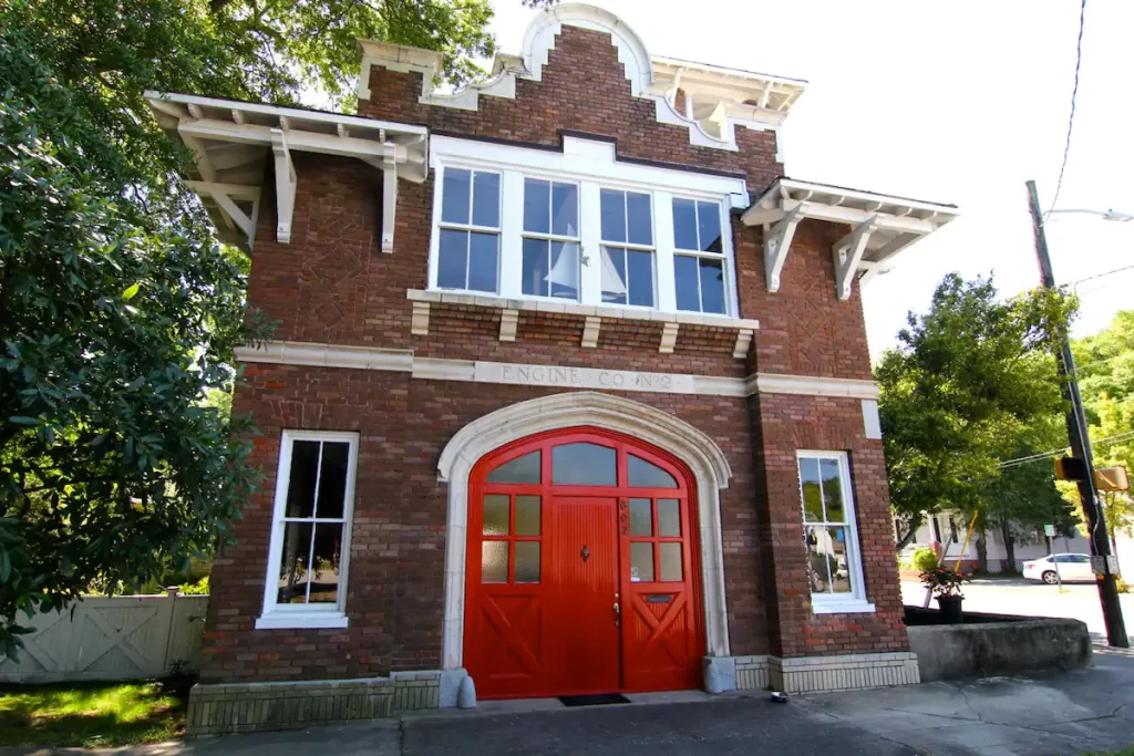 Exterior of Historic Firehouse airbnb, red door, brick building