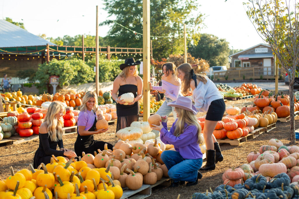 A group of friends choosing pumpkins at Biggers Market, one of our favorite pumpkin patches to visit in the Wilmington area