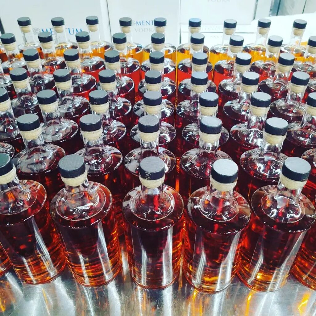Rye whiskey bottles lined up on a metal table from Momentum Distillery Your Guide to Wilmington's Distilleries Arth Real Estate Group
