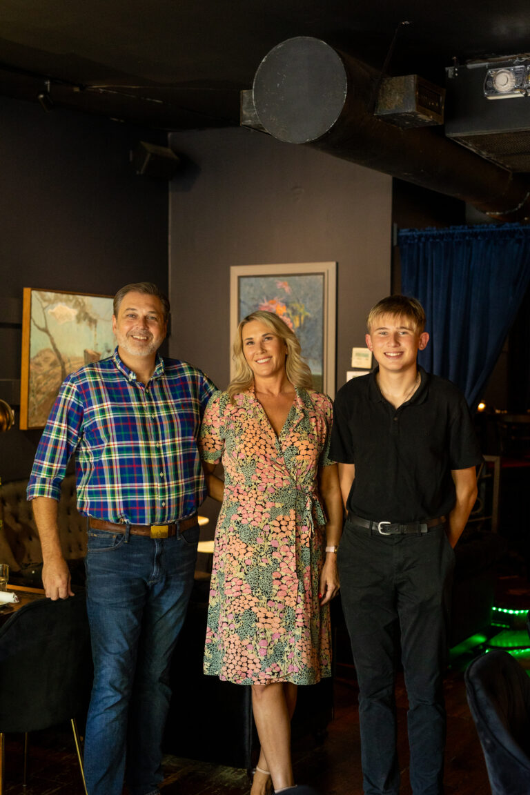 Owners of Caprice, Edie Senter, Dustin Cook, and their son, pose inside Wilmington's beloved restaurant